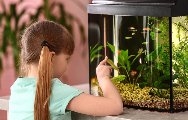 Χαριτωμένο κοριτσάκι κοιτάζοντας τα ψάρια στο ενυδρείο - Φωτογραφία, εικόνα