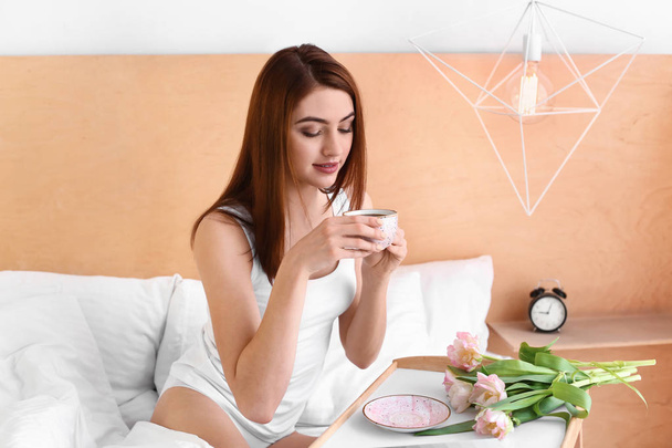 Morning of beautiful young woman drinking coffee in bed - Photo, Image