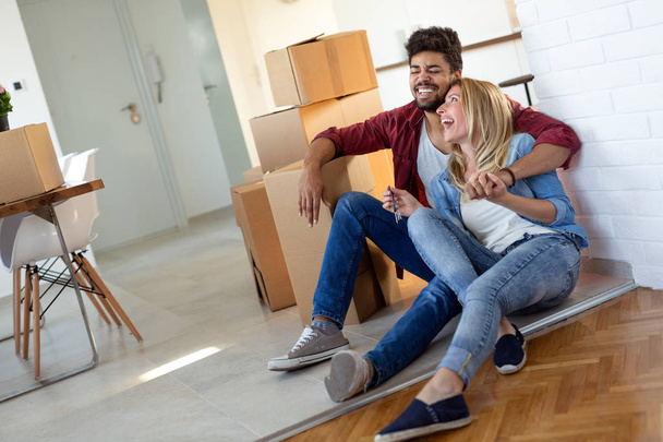 Young married couple Moving in new home and unpacking carboard boxes - Foto, afbeelding