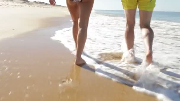 Senior couple as they walk along beach holding hands. - Záběry, video