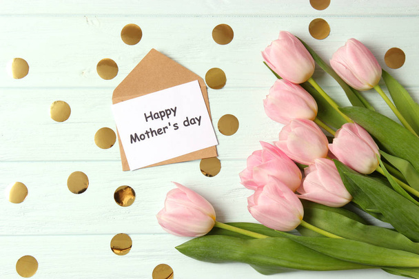 Όμορφη σύνθεση για την ημέρα της μητέρας στο ξύλινο παρασκήνιο κάτοψη. Λουλούδια, ευχετήριες κάρτες, είδη δώρων. - Φωτογραφία, εικόνα