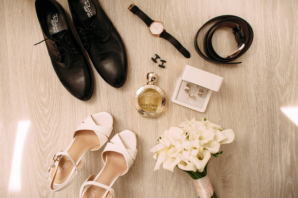 Ramo de boda con tiernas flores blancas, zapatos femeninos, zapatos de cuero negro masculino, reloj de pulsera, gemelos, perfume y cinturón
 - Foto, imagen