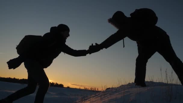 チームワークの方。手をつないで。男性は、手を繋いでいると日没でお互いを引き上げて高雪に覆われた山の頂上を征服する互いを助けます。勝利の追求。困難を克服 - 映像、動画