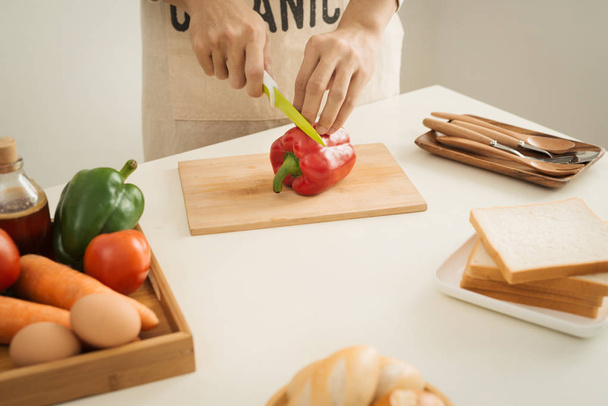 Male hands slicing fresh red bell peppers - Photo, Image
