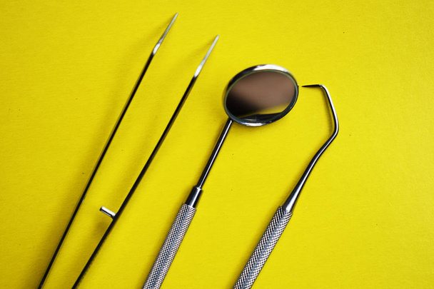 Outils pour le traitement dentaire sur fond jaune
 - Photo, image