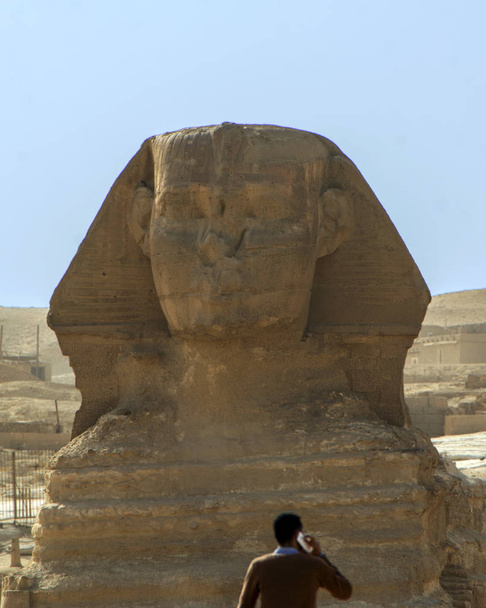 Silhueta borrada do turista falando por smartphone contra a Grande Esfinge de Gizé no fundo, Cairo, no Egito. Cena conceitual mostrando o contraste do passado e hoje em dia
 - Foto, Imagem