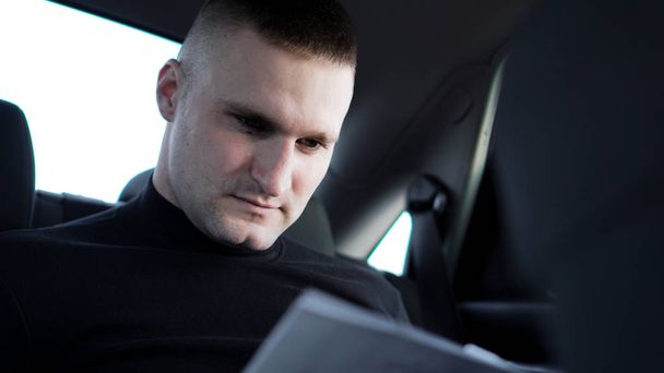 Bir araba arkasında otururken belgeler üzerinden arıyor işadamı - Fotoğraf, Görsel