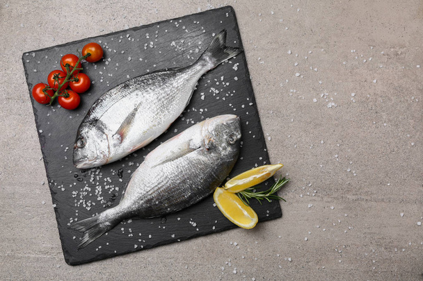 Leisteen plaat met verse vis op tafel - Foto, afbeelding