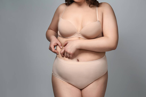 Избыточный вес женщины на сером фоне
 - Фото, изображение