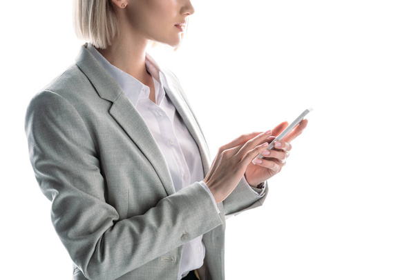 partial view of businesswoman using smartphone isolated on white - Valokuva, kuva