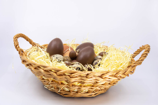 Яичная корзина на Пасху, куриное яйцо, перепелиное яйцо и шоколадное яйцо
 - Фото, изображение