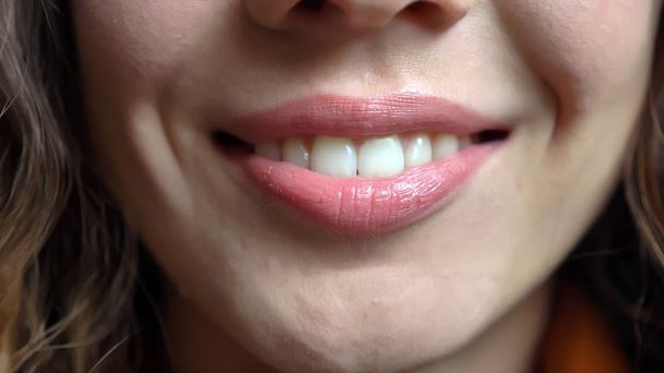 Primer plano de la joven cara femenina bastante caucásica con labios tiernos sonriendo felizmente recto delante de la cámara
 - Foto, Imagen