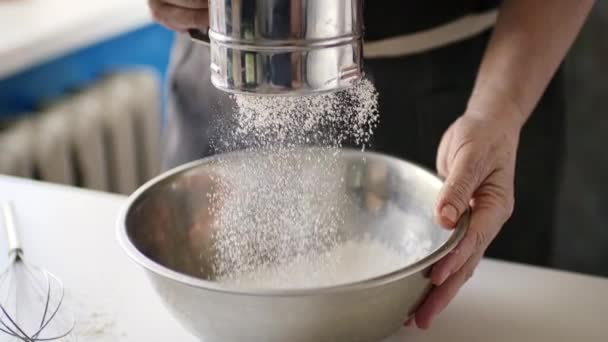 Woman sifting flour in a bowl - Footage, Video