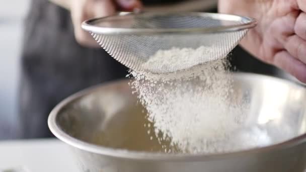 Femme tamisant la farine dans un bol
 - Séquence, vidéo