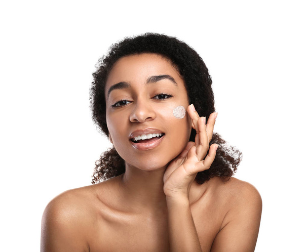 Jonge Afro-Amerikaanse vrouw met scrub op haar gezicht tegen de witte achtergrond - Foto, afbeelding