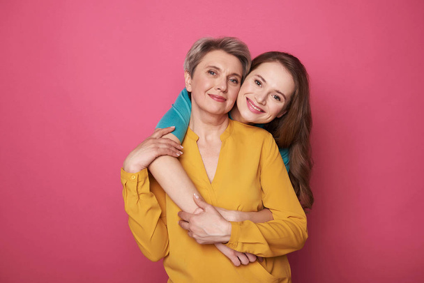 Beautiful woman with her daughter smiling and posing for camera - Fotografie, Obrázek