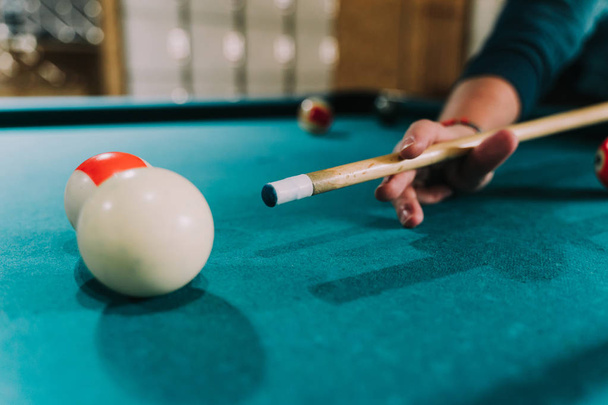 A hand with a tazo points to a billiard ball - Фото, изображение