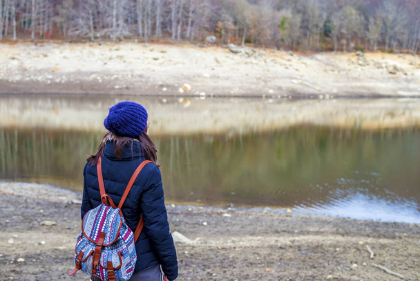 Donna escursionista con zaino in piedi vicino al lago. Turista femminile sta godendo la vista nella natura
 - Foto, immagini