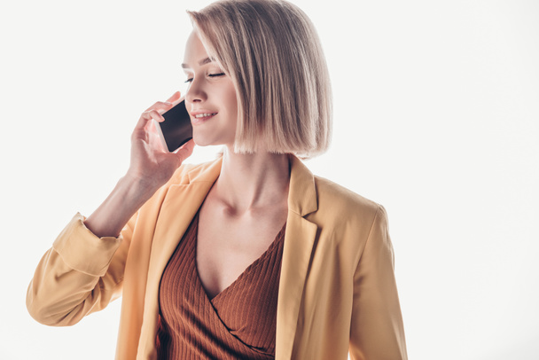 smiling, beautiful woman with blonde hair talking on smartphone on grey - Фото, зображення