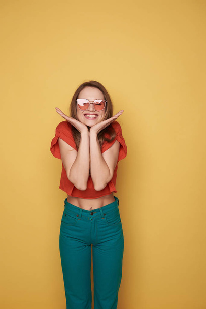 Waist up of smiling brunette young lady in eyeglasses posing for camera - Фото, зображення