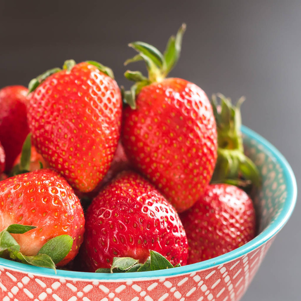 strawberries in the bowl on black background - Fotó, kép