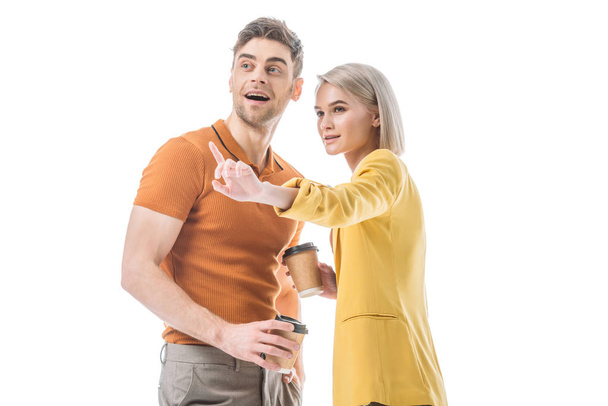 pretty young woman pointing with finger while standing near handsome man isolated on white - Photo, Image