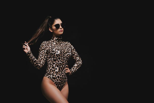 Alluring young brunette in leopard bodysuit - 写真・画像