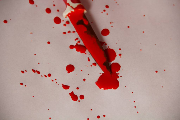 cuchillo con sangre sobre papel blanco
 - Foto, Imagen