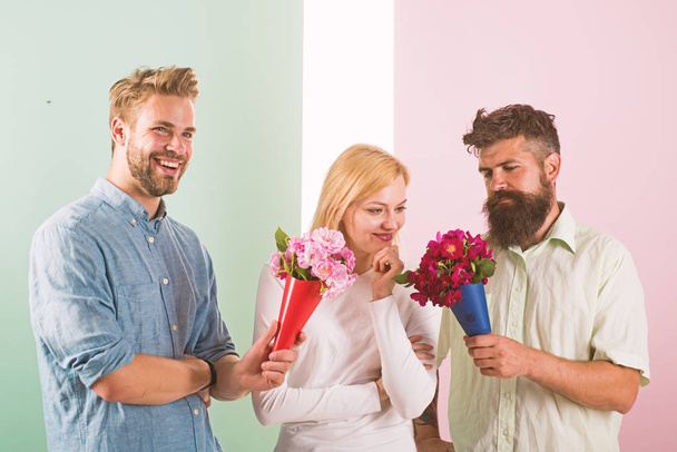 Men competitors with bouquets flowers try conquer girl. Girl likes to be in middle attention. Love triangle. Woman thoughtful has opportunity choose partner. Girl popular receive lot men attention - Fotoğraf, Görsel