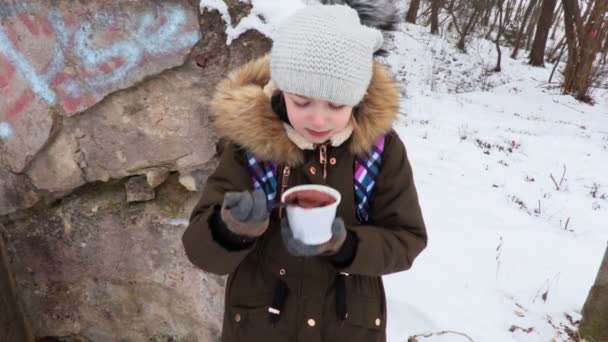  Dítě konzumní čokoládový pudink poblíž betonové zdi v zimě - Záběry, video