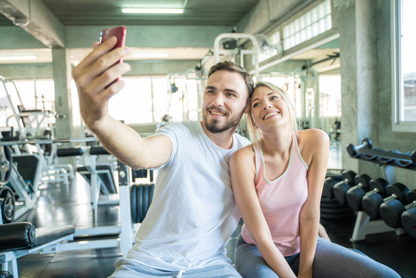 Casal esporte caucasiano tirar selfies foto após o exercício no ginásio
 - Foto, Imagem