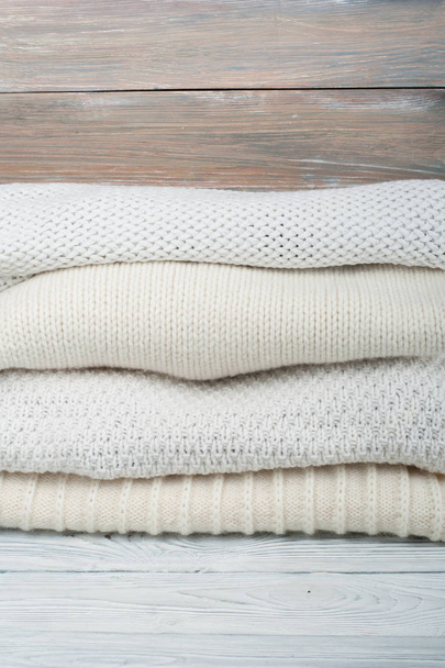 Camisolas de lã de malha. Pilha de roupas de inverno de malha em fundo de madeira, blusas, malhas, espaço para texto - Foto, Imagem