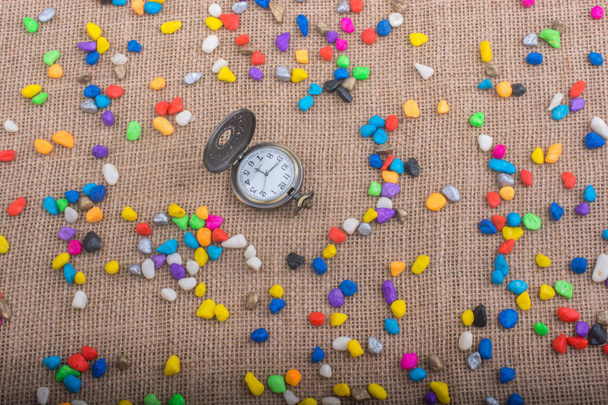 Pocket watch amid Colorful pebbles  - Photo, Image