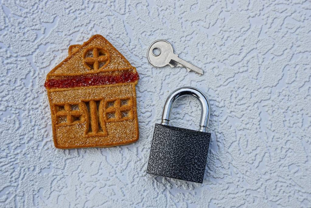 Kulcs-val egy bezár, és egy cookie-ház, egy szürke háttér - Fotó, kép