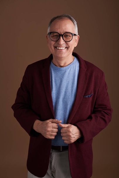 Handsome adult smiling and posing in maroon jacket - Φωτογραφία, εικόνα