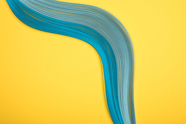 top view of curved blue lines on yellow background - Foto, immagini