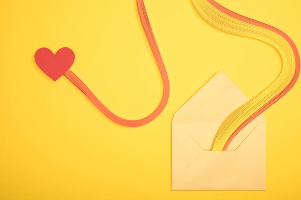 top view of open envelope with rainbow and heart sign on yellow background - Photo, Image