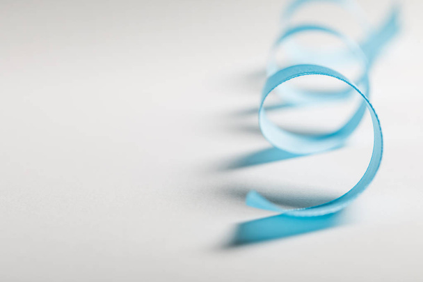 close up de fita de cetim azul curvo em fundo cinza com espaço de cópia
 - Foto, Imagem