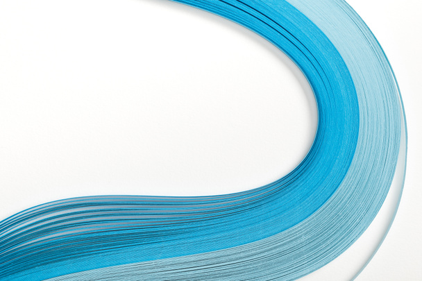 close up of wavy blue abstract paper lines on white background - Foto, imagen