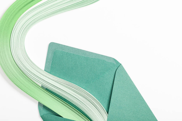 close up of green envelope with multicolored rainbow on white background - Photo, Image