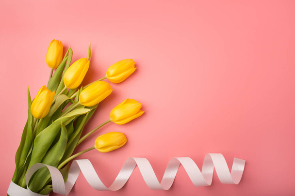 Spring card: yellow tulips on a coral background. Top view, lay flat - Fotó, kép