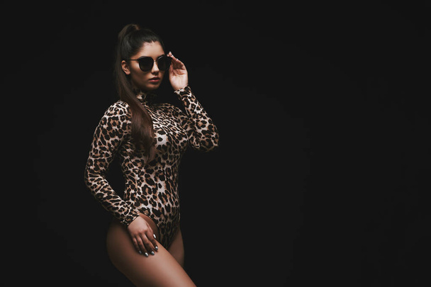 Alluring young brunette in leopard bodysuit - Фото, изображение