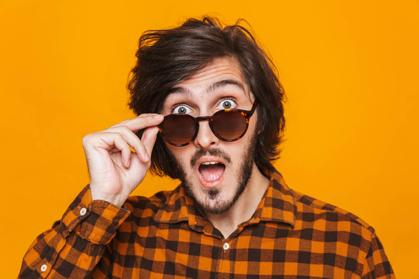 Portrait of trendy guy 20s wearing plaid shirt smiling and looki - Foto, Bild