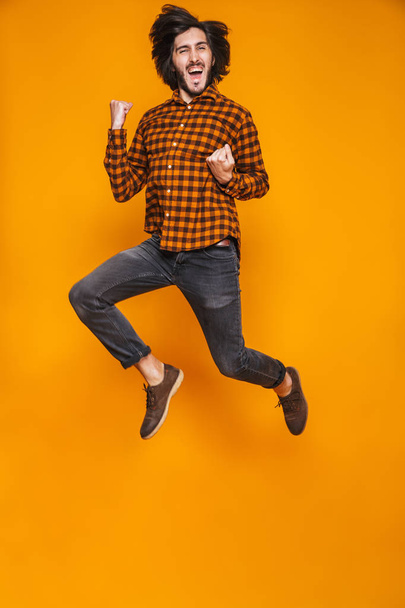 Pełnej długości piękny portret pozytywny człowiek 20s noszenia plaid skoki - Zdjęcie, obraz