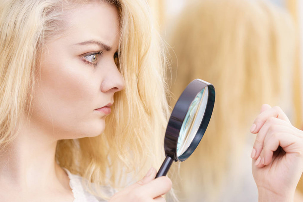 Woman magnifying her split ends hair - Photo, image