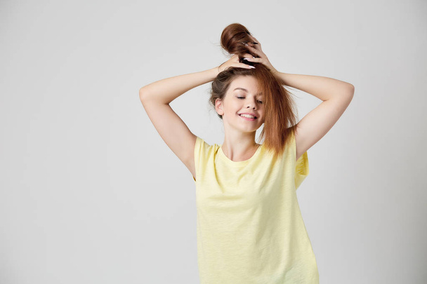 Girl in yellow t-shirt fooling around with her hair - Фото, зображення
