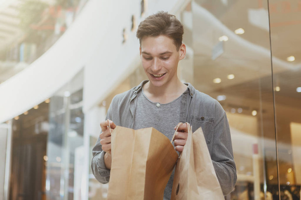 Beau jeune homme faisant du shopping au centre commercial
 - Photo, image