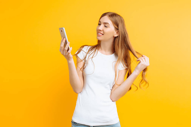 Beautiful young woman , uses a mobile phone, for messaging, look - Φωτογραφία, εικόνα