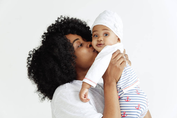 Portret van mooie Afrikaanse vrouw houden op handen haar kleine baby - Foto, afbeelding