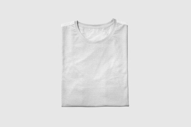 Camiseta blanca en blanco plegado Mock-up sobre fondo gris suave, vista frontal. Listo para reemplazar su diseño
. - Foto, imagen